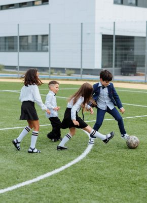 pexels photo 8927023 8927023 Group of children playing soccer on a school field, enjoying outdoor fun and recreation.